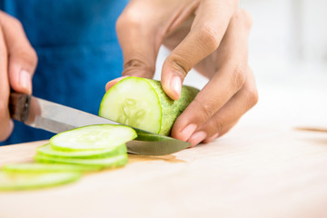 Cucumber being sliced  by a knife