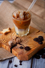 The Hong Kong iced coffee in a glass,with a straw. interesting wooden background