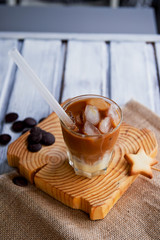 The Hong Kong iced coffee in a glass,with a straw. interesting wooden background