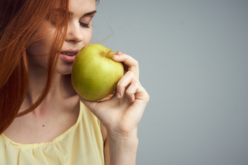 Diet, nutrition, apple, woman with apple, woman on gray background