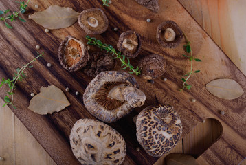 top view dried shiitake mushroom with herb on wooden board
