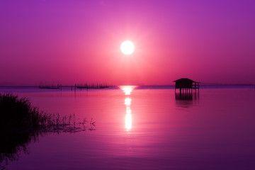 Sunset in pink sky on the lake.