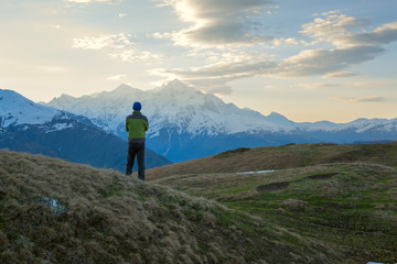 Fototapeta na wymiar Lonely traveler admires the sunrise over the mountain peaks