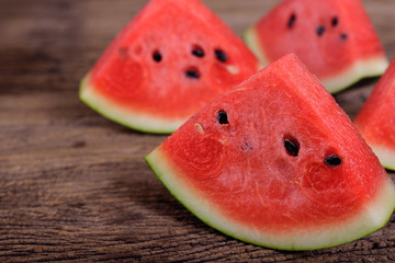 portion cut fresh watermelon with seed on wooden table