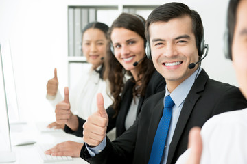 Smiling customer support team giving thumbs up