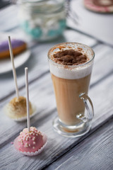 Coffee cappuccino with beautiful sweets on wooden background.Beautiful sweets