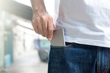 A man picking up cell phone from jeans pocket