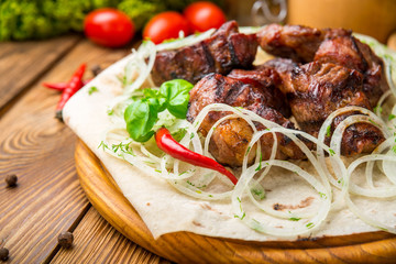 Pieces of meat with onions on skewers