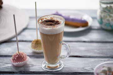 Coffee cappuccino with beautiful sweets on wooden background.Beautiful sweets