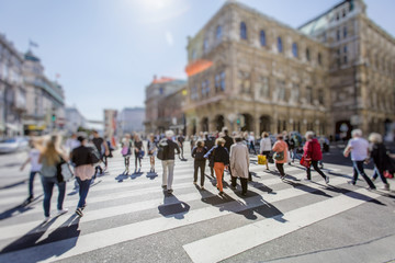 Busy Pedestrian Crossing over zebra on sunny day in the city