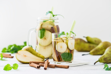 Refreshing drink with pear, cinnamon on white rustic table