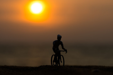 Obraz na płótnie Canvas Silhouettes model of cyclists on the beach with sunset.
