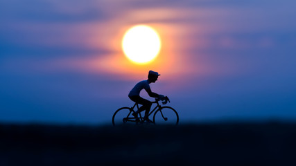 Fototapeta premium Silhouettes model of cyclists on the beach with sunset.