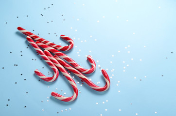 Creative layout made of lollipop cane and sparkling stars. Christmas holiday background, minimal s concept.