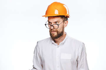 Engineer in a helmet, a construction helmet, a builder with glasses, a designer on a light background