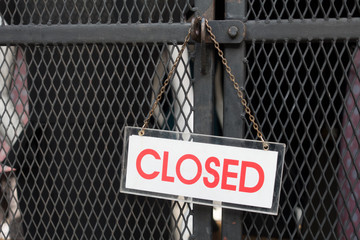 Closed sign hang on metal fence.