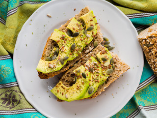 Avocado cereal sandwich for healthy snack with seeds on green napkin