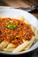 Pasta penne with tomato bolognese sauce.