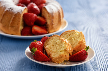 Homemade cake with strawberries on wooden background.