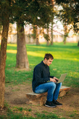 Obraz premium The young manager working on a laptop in the park. Lunch Break.