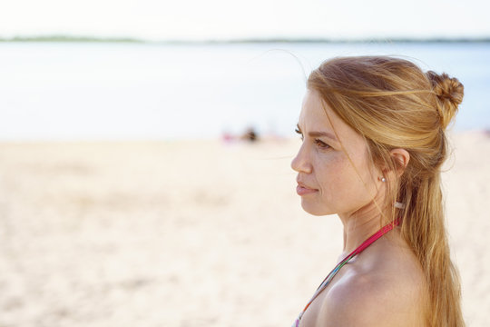 Thoughtful woman watching something on a beach