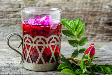 Cup of tea with rose petals, hot drink for autumn cold and flu