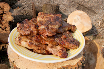 Juicy pork steaks cooked on an open flame grill on big white plate..