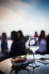 Obraz premium glass of white wine with gourmet food tapa snacks outside