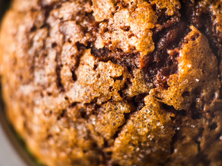 Banana chocolate muffins with caramel sugar topping on dark background