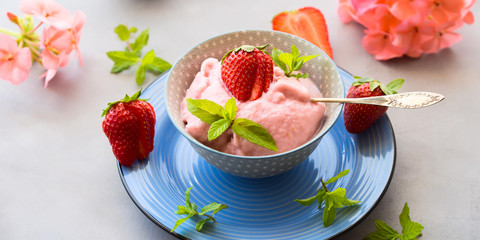 Home made strawberry ice cream in bowl with min leaves