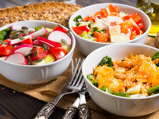 Colorful vegetable salad bowl for lunch on wooden rustic background