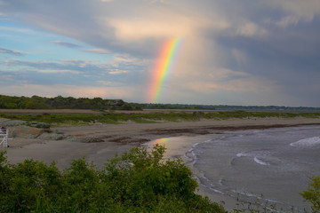 Rainbow over the ocean at Second Beach in Newport, Rhode  Island. Coastal sunset, New England summer, rainbows over water,  after the rainstorm, seaside, ocean beach, colorful rainbow over the ocean