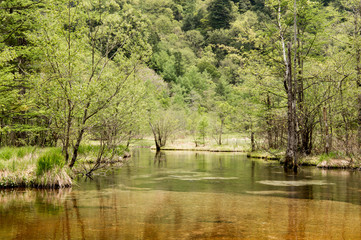 Fototapeta na wymiar Hotaka mountain range and taisho ike pond in spring at kamikochi national park nagano japan