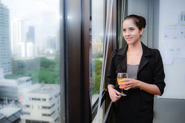 smile of beautiful business woman at the window with champagne, Look through the window  thinking for business