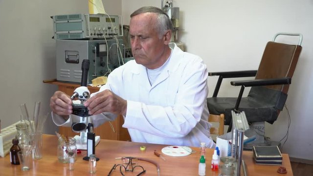 Professor working with blood in the laboratory with microscope