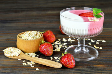 Strawberry yogurt and muesli on wooden background
