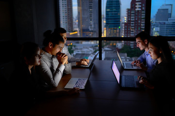 business team working with computer overtime at night and low light