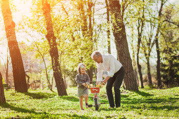 Grandfather with girl and bicycle