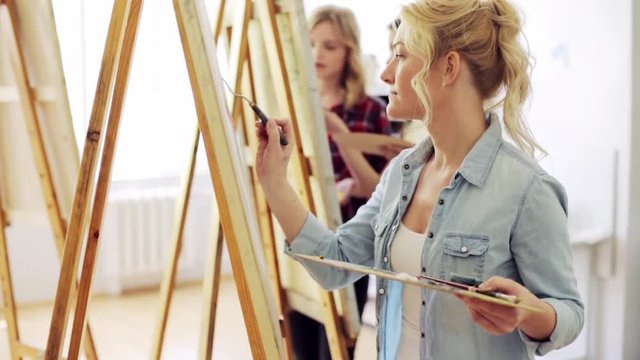 students with easels painting at art school