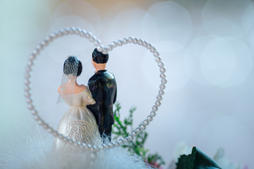 Bride and groom doll on bouquet in wedding ceremony.