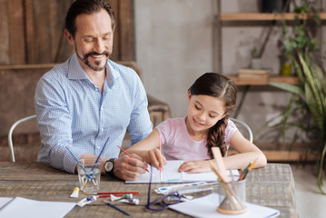 Pleasant inspired father painting sky with his daughter