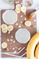 Milk cocktail with banana, almonds and honey, top view, selective focus