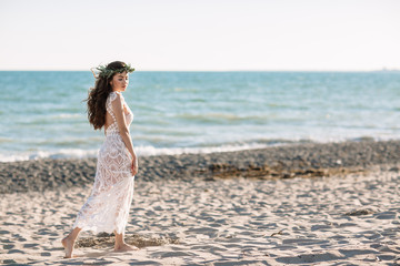 Beautiful girl on the beach in a beautiful dress. Sunny day, white sand, boho