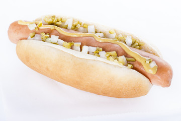 Hot dog grill with mustard, onion and pickles isolated on white background.