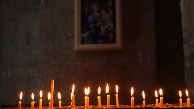 Candles burning in front of icon of the madonna with child in ancient armenian church