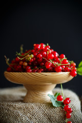 Ripe red currant in a wooden vase