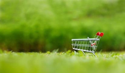 Close up shot of shopping cart over nature green background shallow depth of field