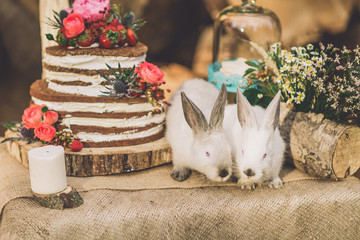 decorated table for two decorated with floral composition wood background with 2 rabbits