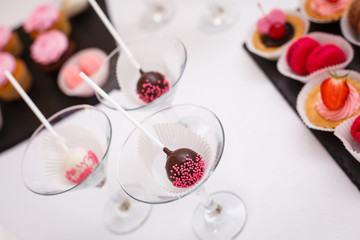 Home made chocolate cake pop decorated with pink and white sugar sprinkles.