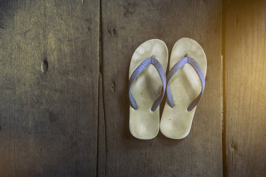 White flip flops Sandals on the floor of an old white wooden in home,